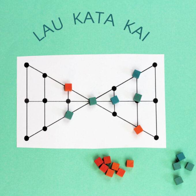 Lau Kata Kai game board in double triangle shape with some pieces on board, on green background