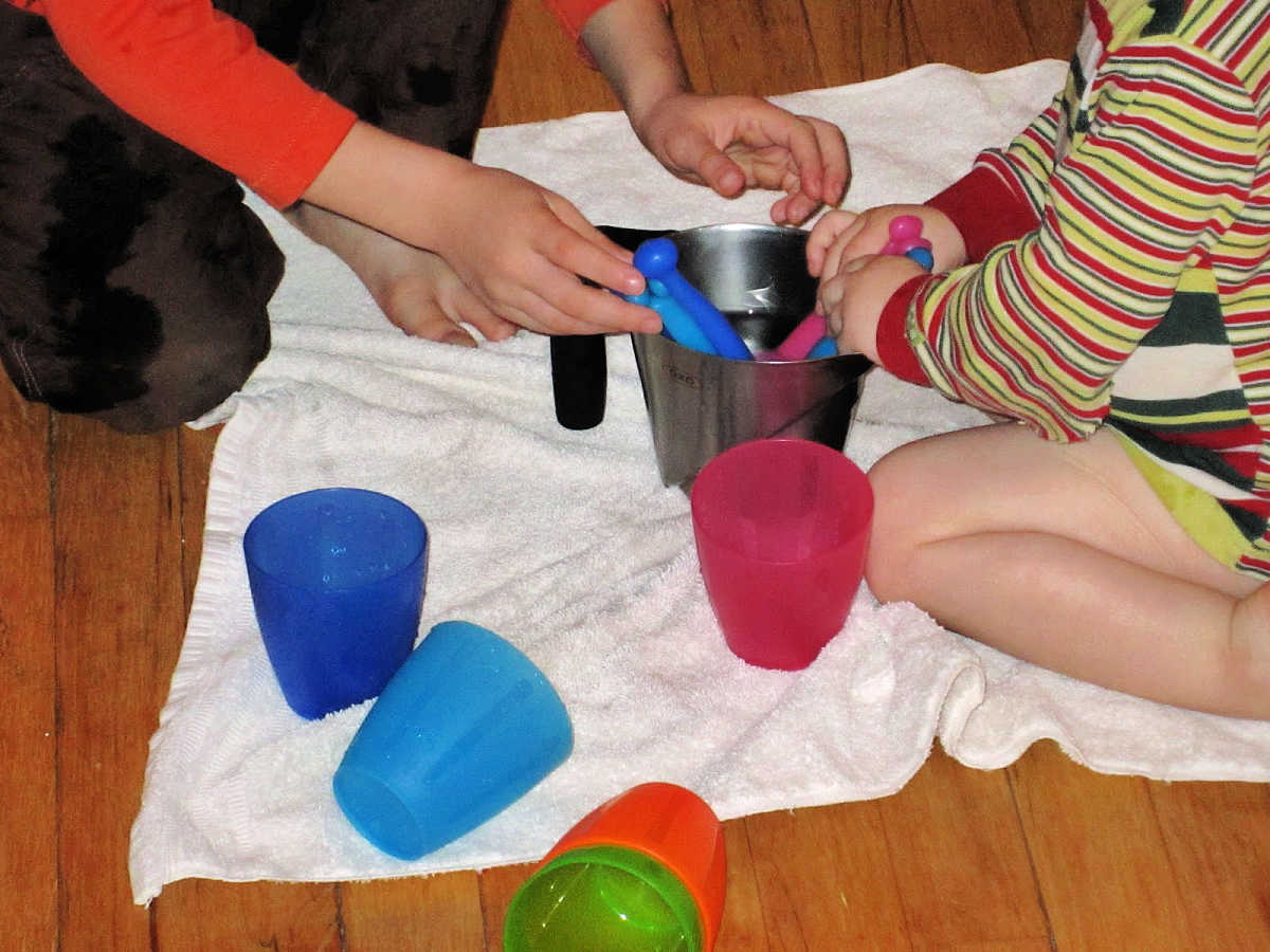 Kids playing with water cups and spoons